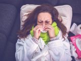 Woman suffering from influenza sleeping in bed